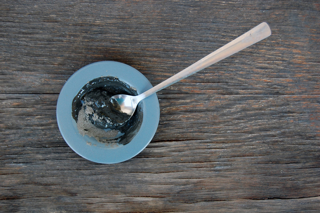 Blue bowl of facial clay with silver spoon