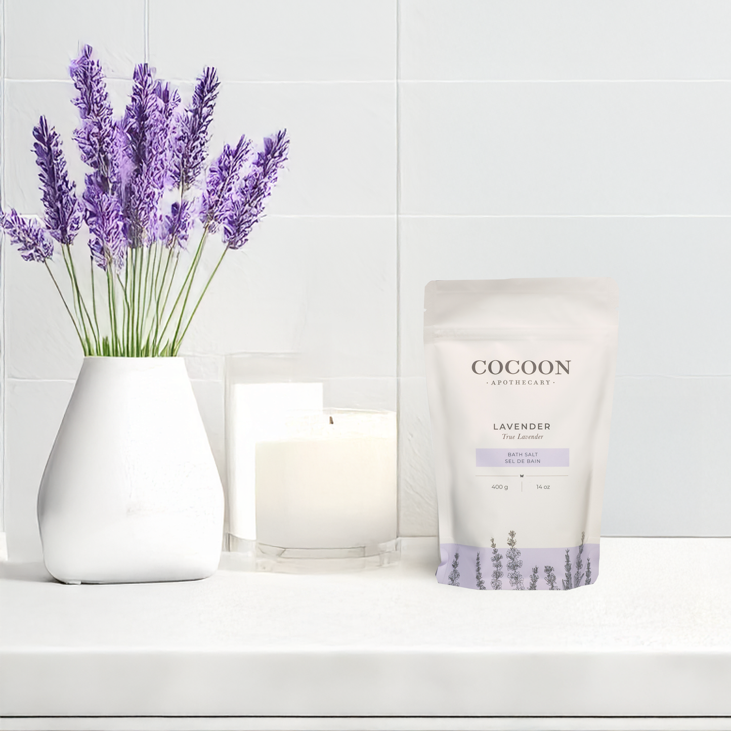 Cocoon lavender product with a vase of lavender and a candle on a white surface.
