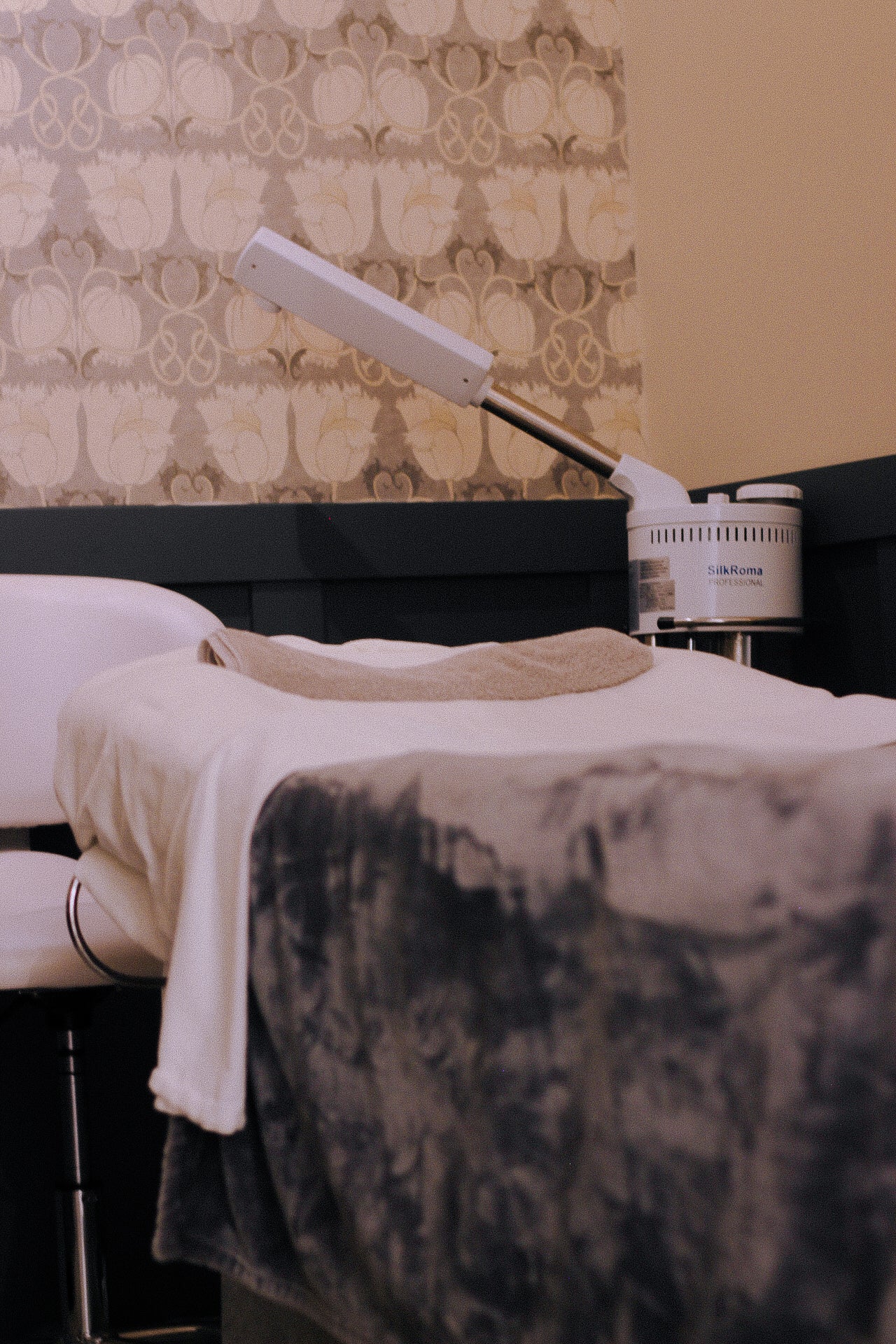 Treatment bed with a towel and lamp in a clinical setting