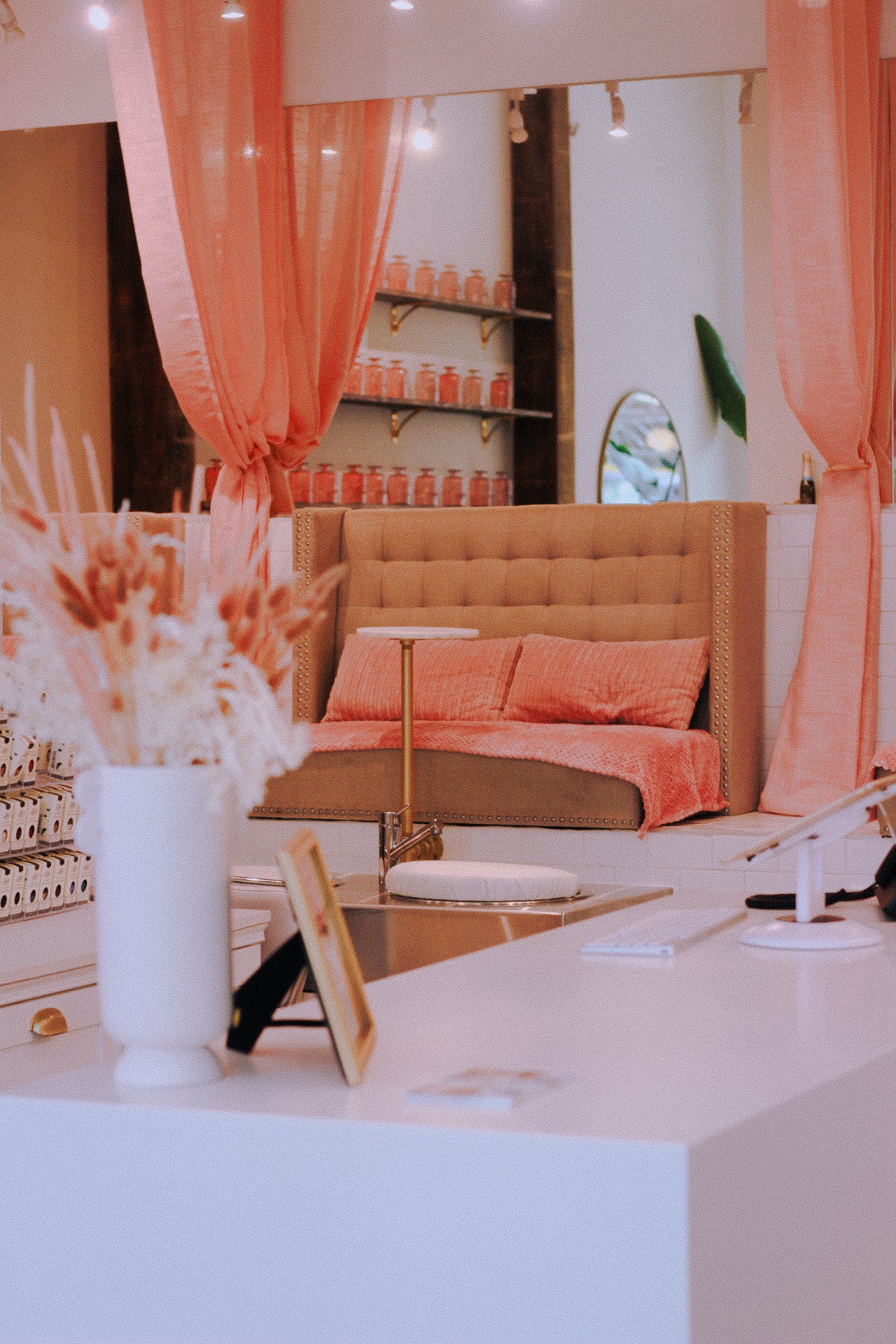 Decorative interior with orange curtains, sofa, and shelves.