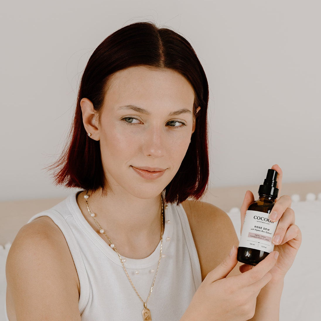 Spraying Rose Dew Facial Toner mist over skin