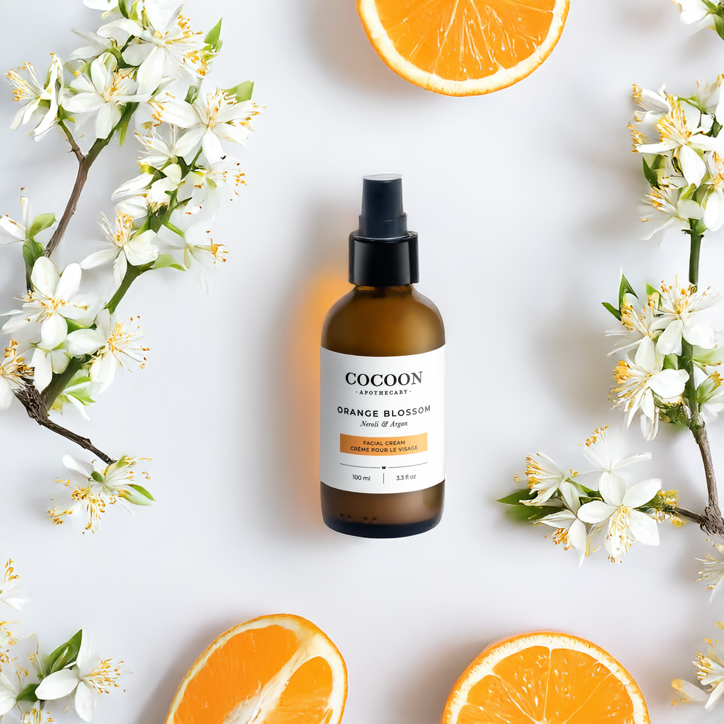 Cocoon skincare bottle with orange blossoms and oranges on a light background