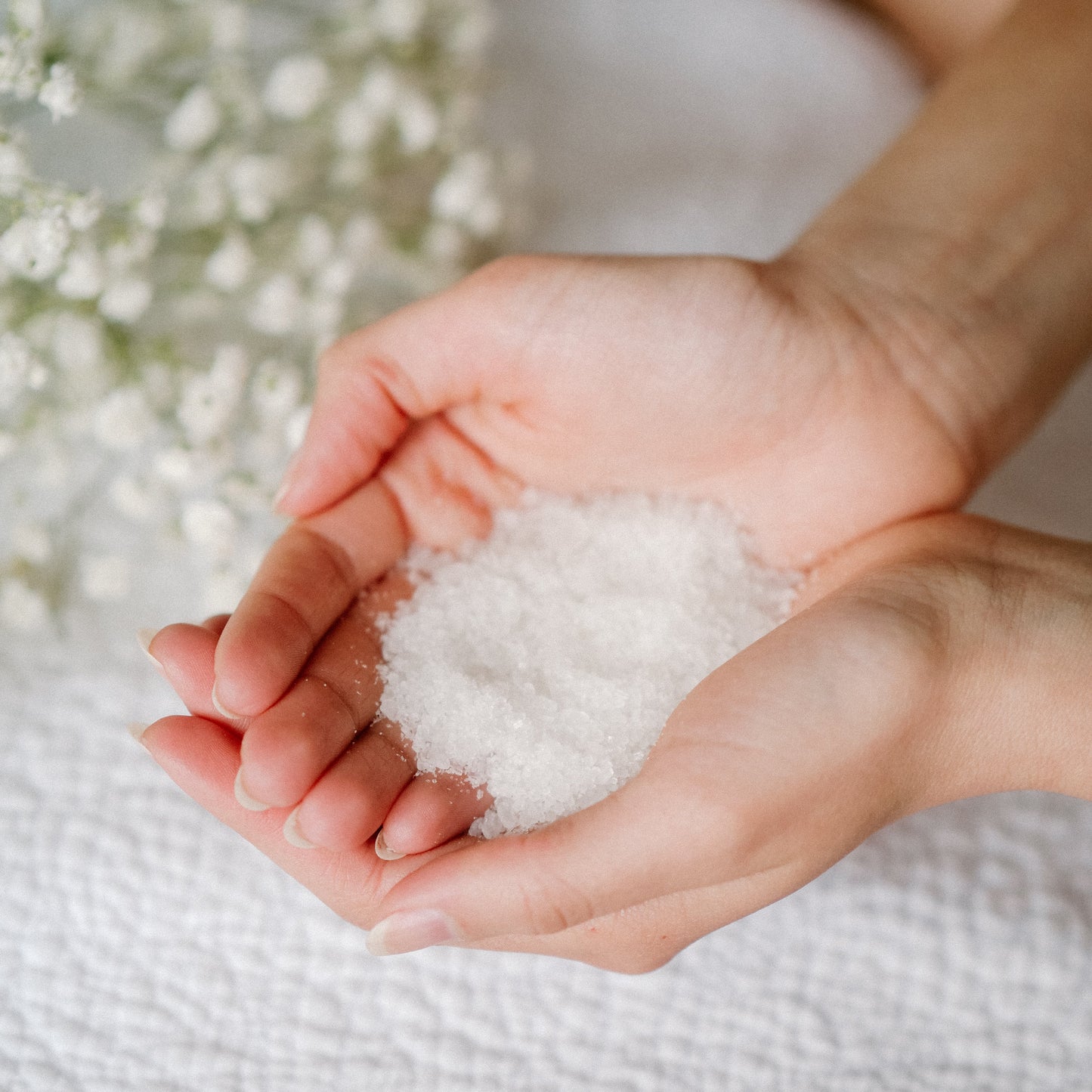 Hands holding a nourishing bath salt