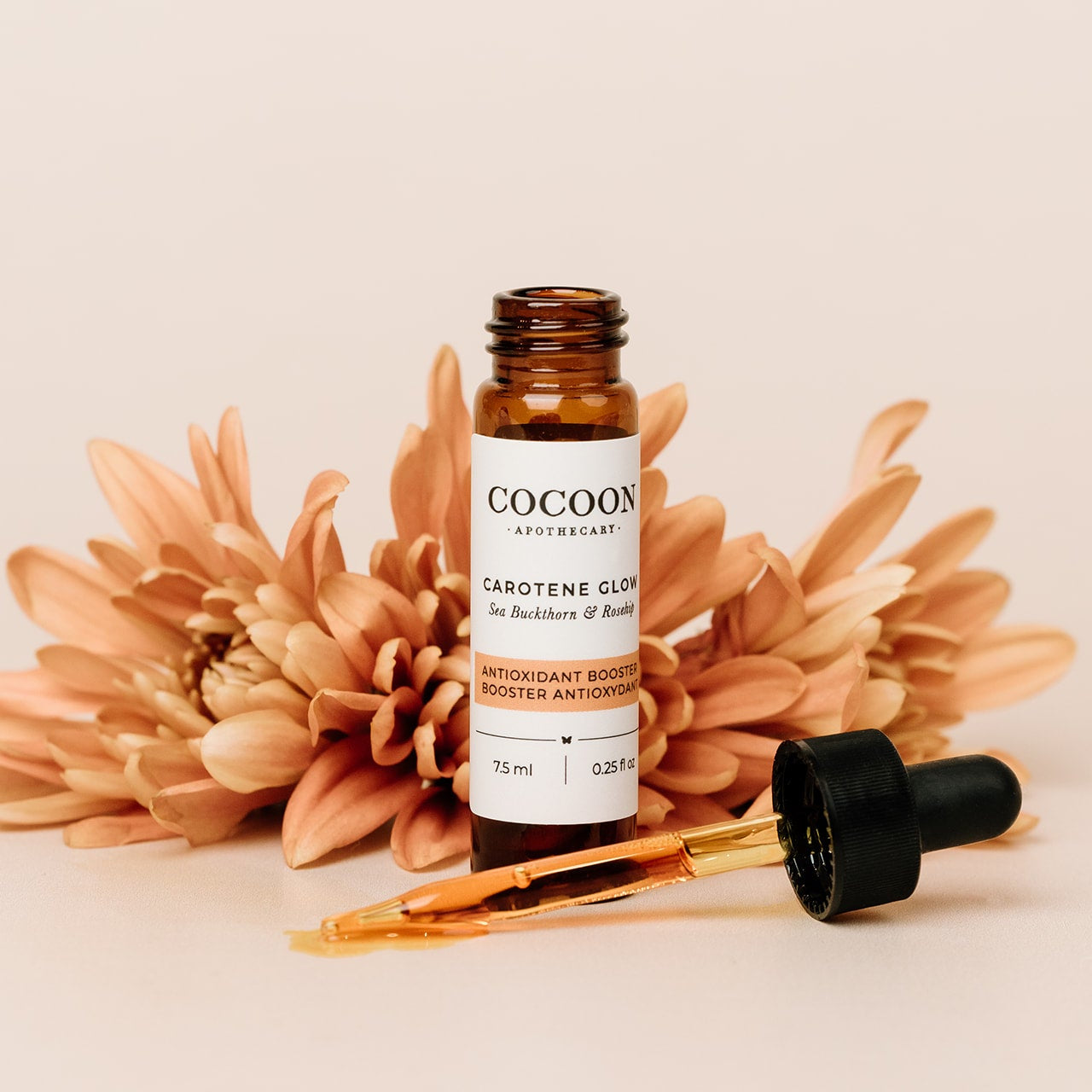 Cocoon skincare bottle with dropper and flowers on a beige background