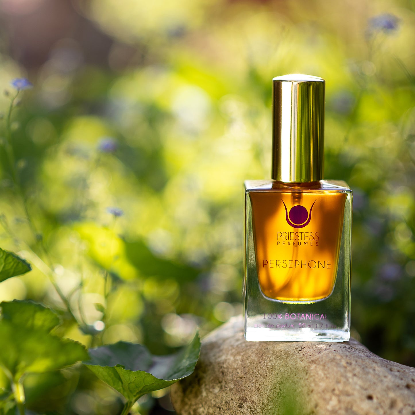 Perfume bottle on a rock with greenery in the background