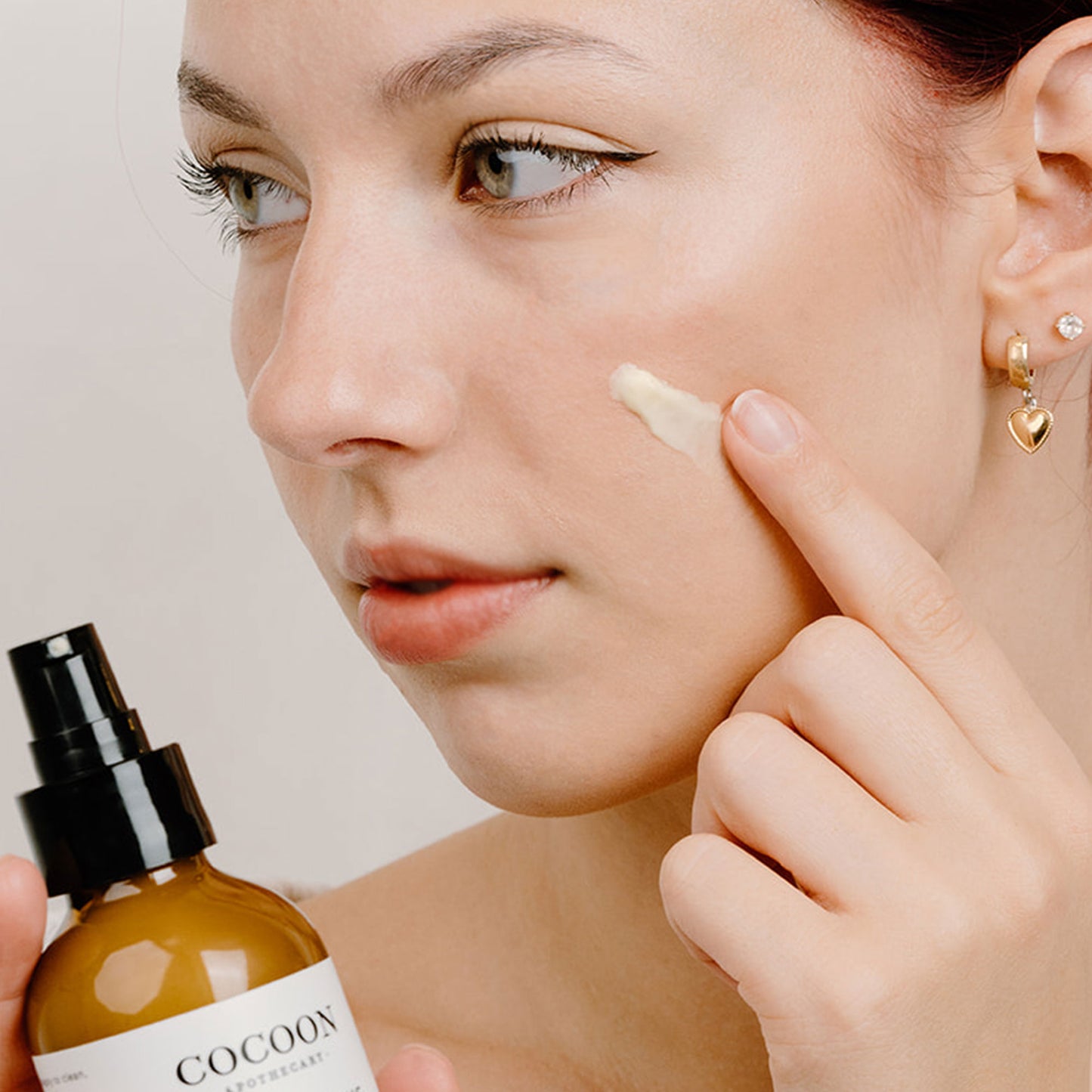 Applying Rosey Cheeks Facial Cream to face for soothing hydration and redness relief – gentle care for sensitive skin.