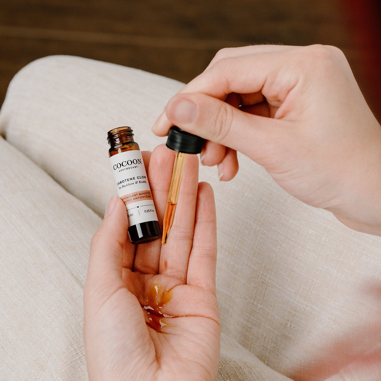 Close-up drop of Carotene Glow serum on skin