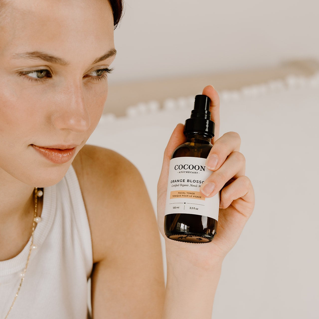 Spraying Orange Blossom Facial Toner mist over skin