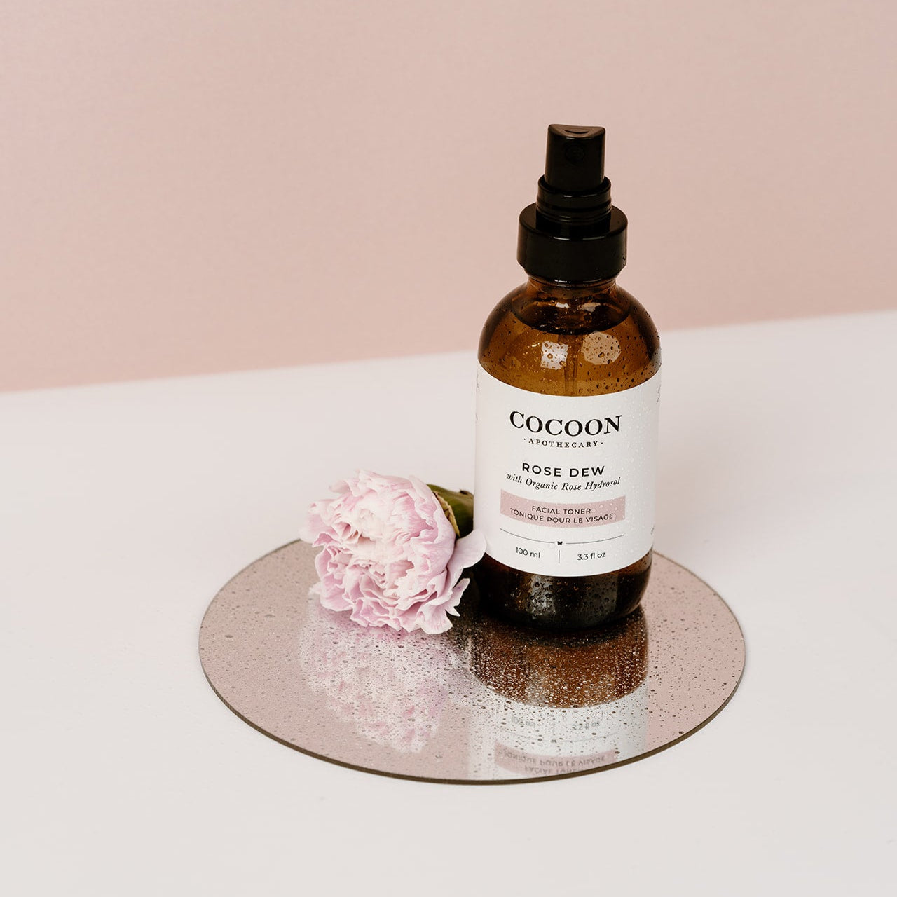 Rose Dew Facial Toner on mirror with rose petals