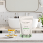 Cocoon Apothecary Citrus Tea package on a bathroom counter with a cup and saucer.