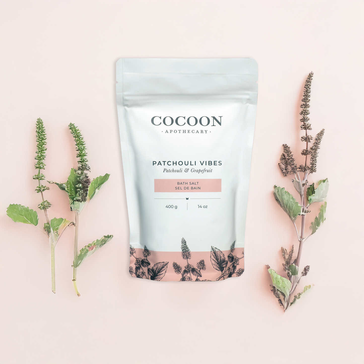 Cocoon Apothecary Patchouli Vibes product packaging with herbs on a pink background