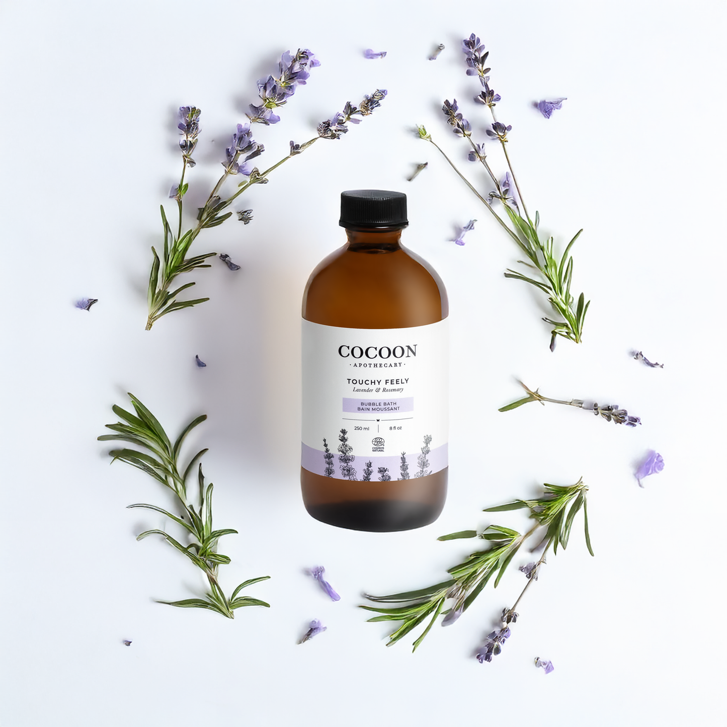 Cocoon bottle surrounded by lavender and rosemary on a white background