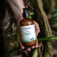 Kahuna Body Lotion glass bottle in a tropical setting – eco-friendly skincare part of Cocoon Apothecary Bottle Return Program.