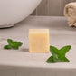 Bar of soap with mint leaves on a bathroom counter