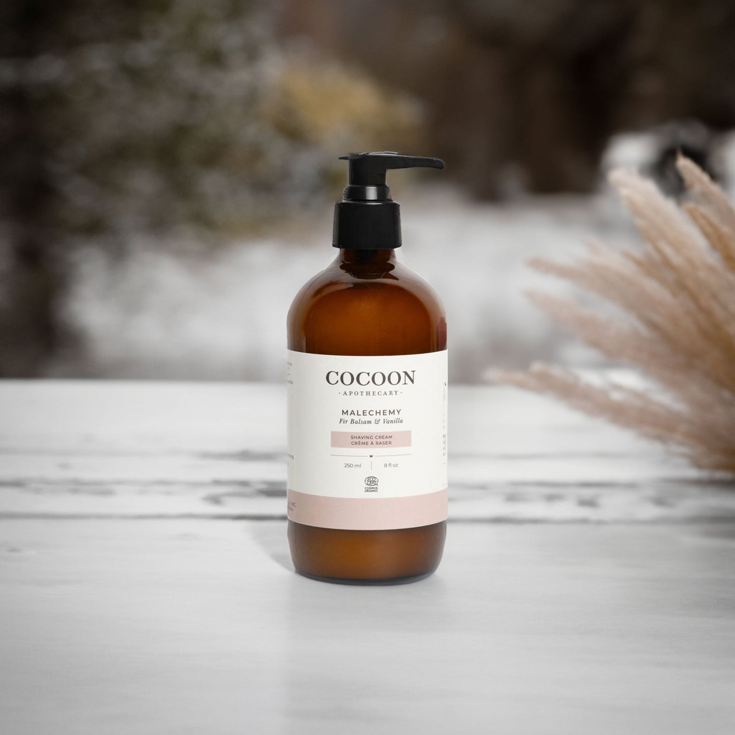 Cocoon bottle with pump on a wooden surface with blurred natural background