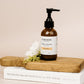 Cocoon skincare bottle on a wooden board with a white flower
