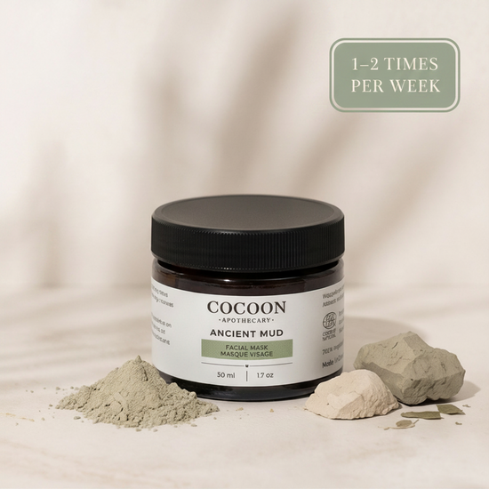 Cocoon Apothecary Ancient Mud facial mask jar with mud and rocks on a beige background