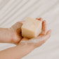 Hand holding a bar of soap with a light background