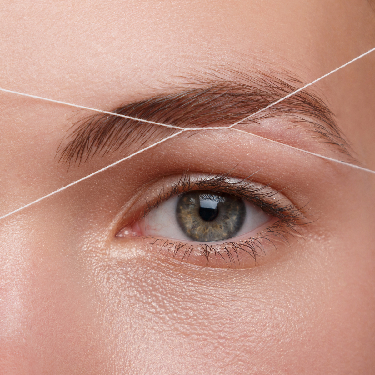 a person getting their eye brows lightly threaded