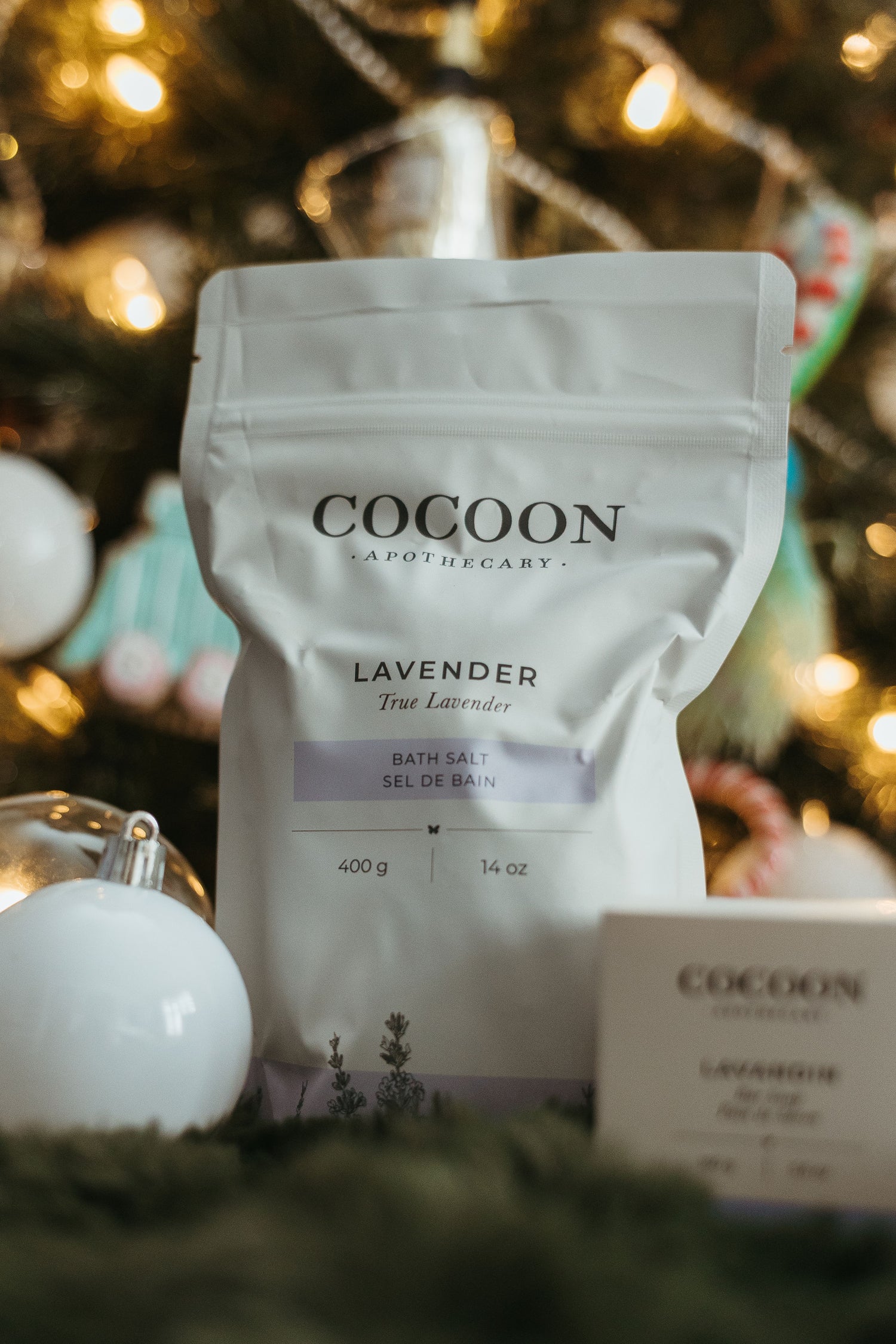 Cocoon lavender bath salt packaging with a blurred festive background