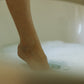 dipping a toe in a luxurious bubble bath