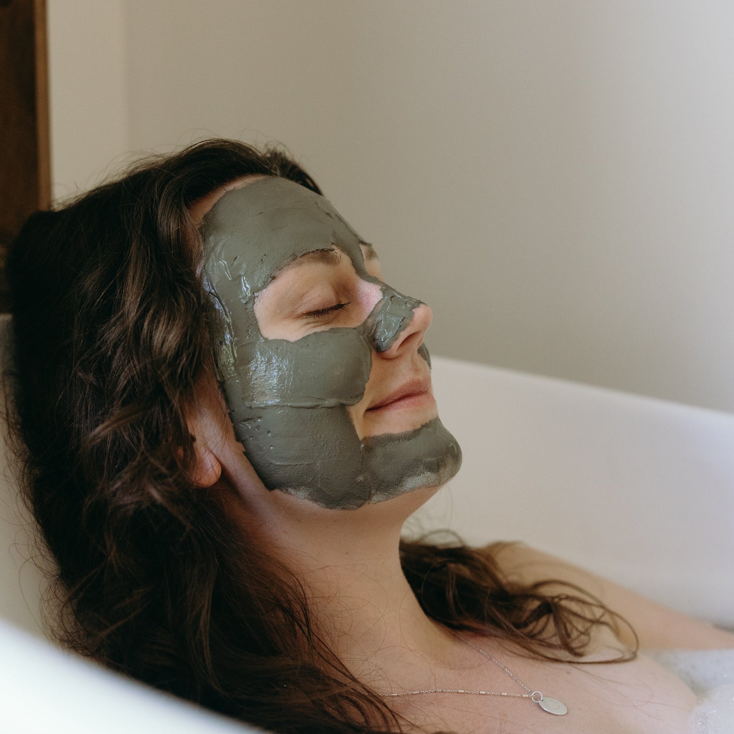 mud mask applied and setting while soaking in a tub