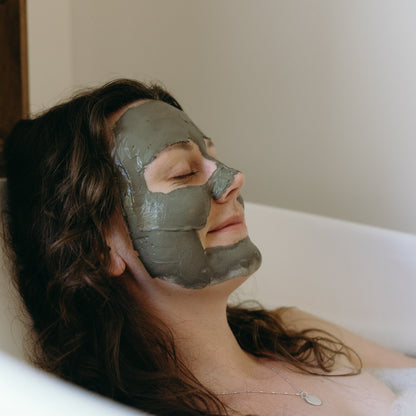 mud mask applied and setting while soaking in a tub