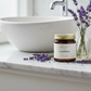 Lavandin Candle on a bathroom counter with lavender flowers