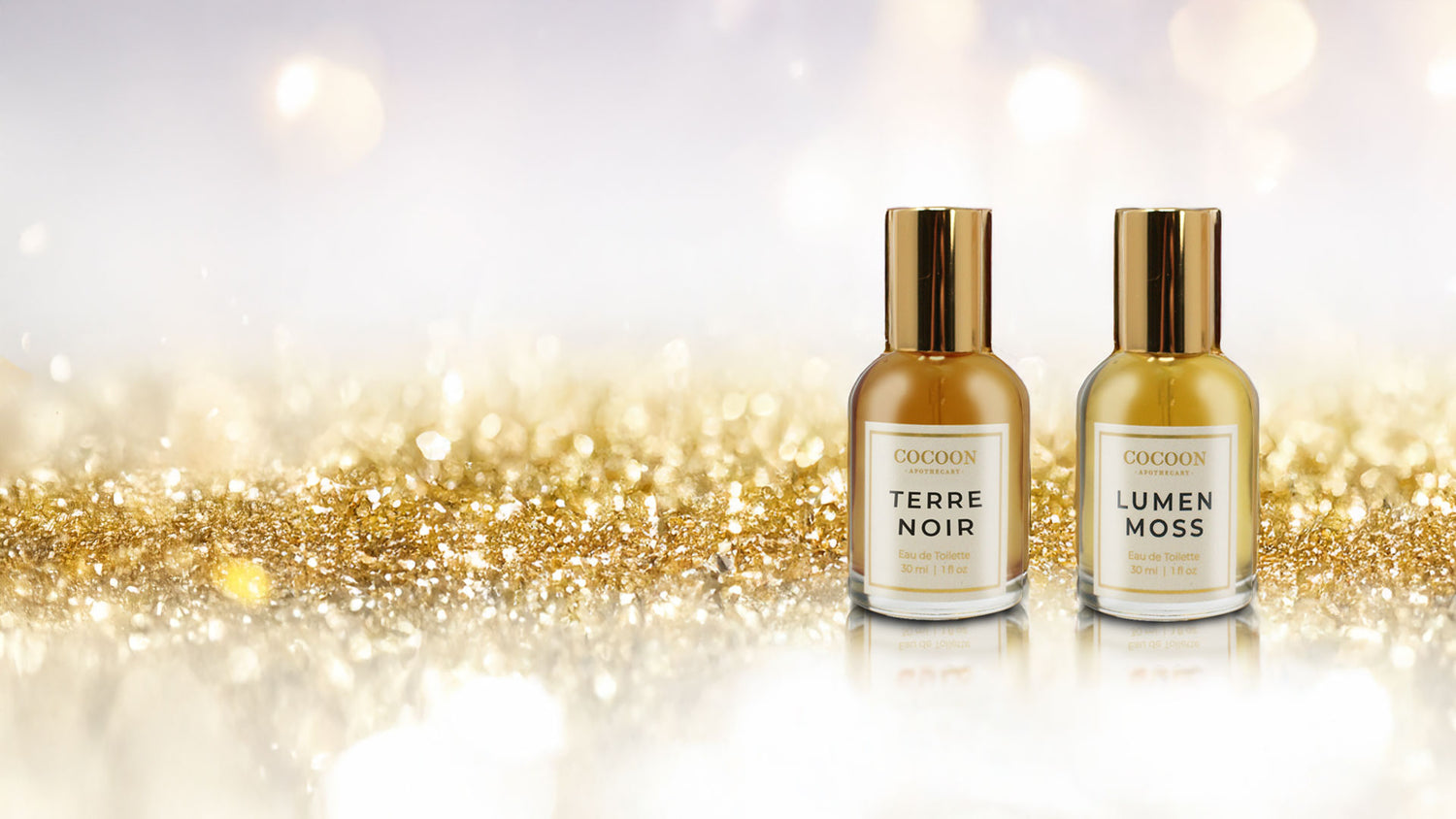 Two perfume bottles labeled 'Terre Noir' and 'Lumen Moss' on a glittery gold and white background.