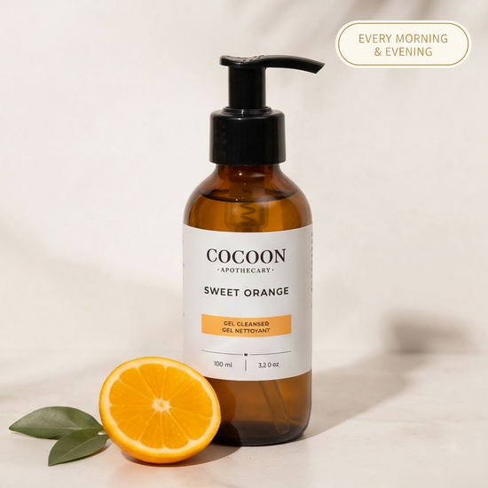 Cocoon Apothecary Sweet Orange gel cleanser bottle with an orange and leaves on a light background
